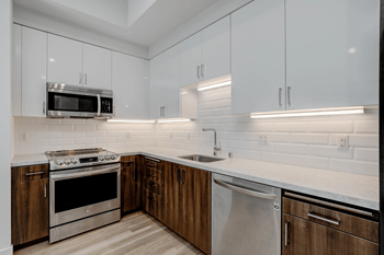 a kitchen with white cabinets and stainless steel appliances